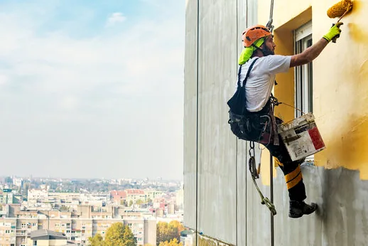 Rope-access painter working high on a commercial wall in Santa Clarita